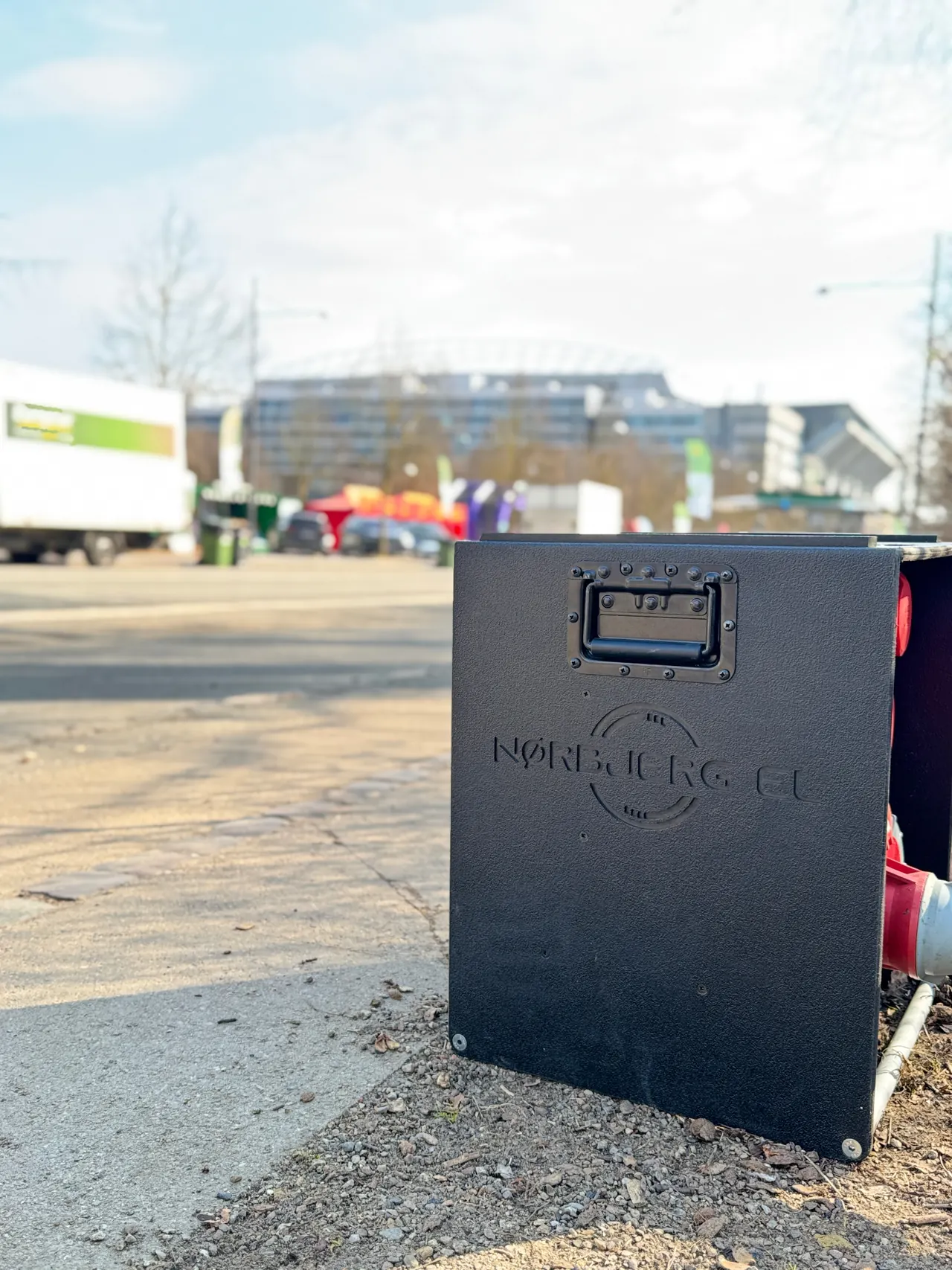 Sort Nørbjerg El-strømboks på en eventplads i aftenlys