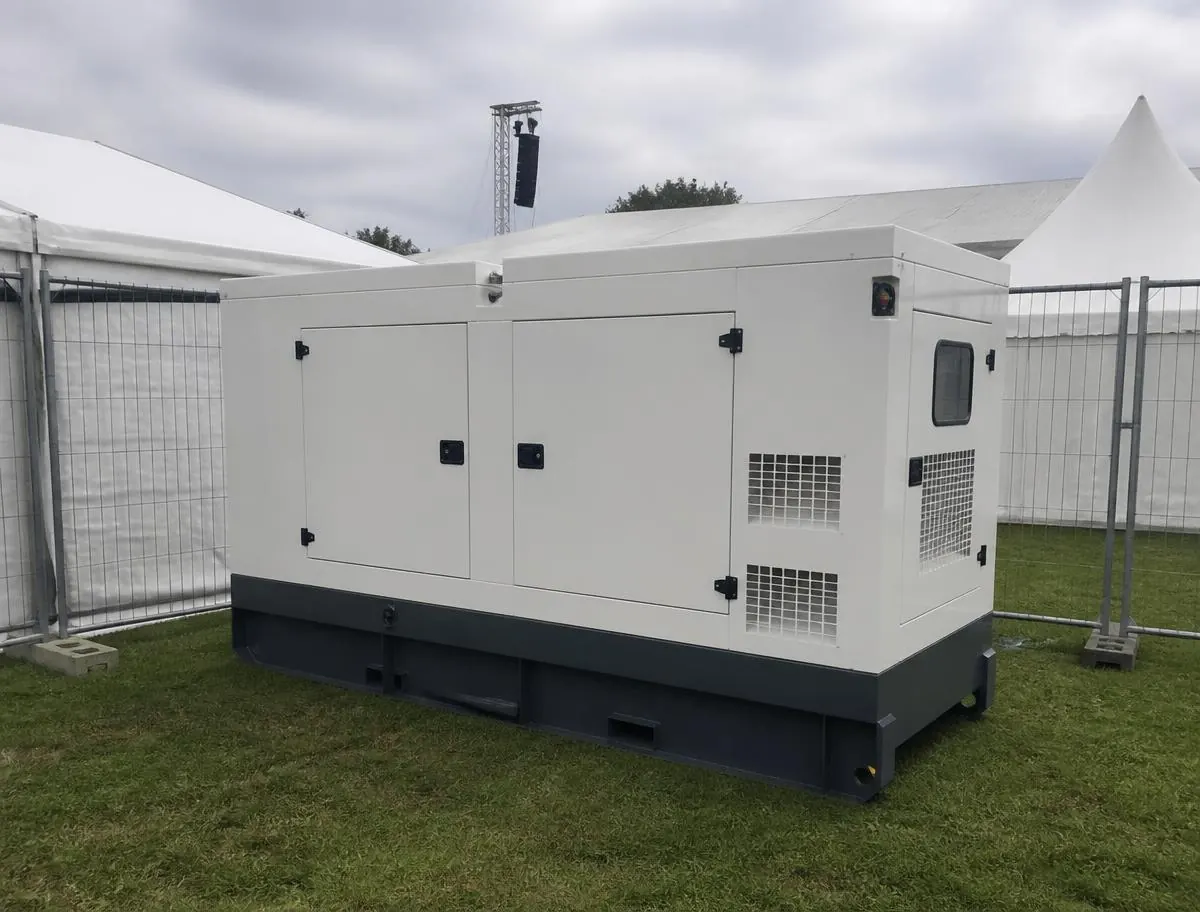 Lydsvag hvid generator opstillet på en græsplæne ved eventtelte