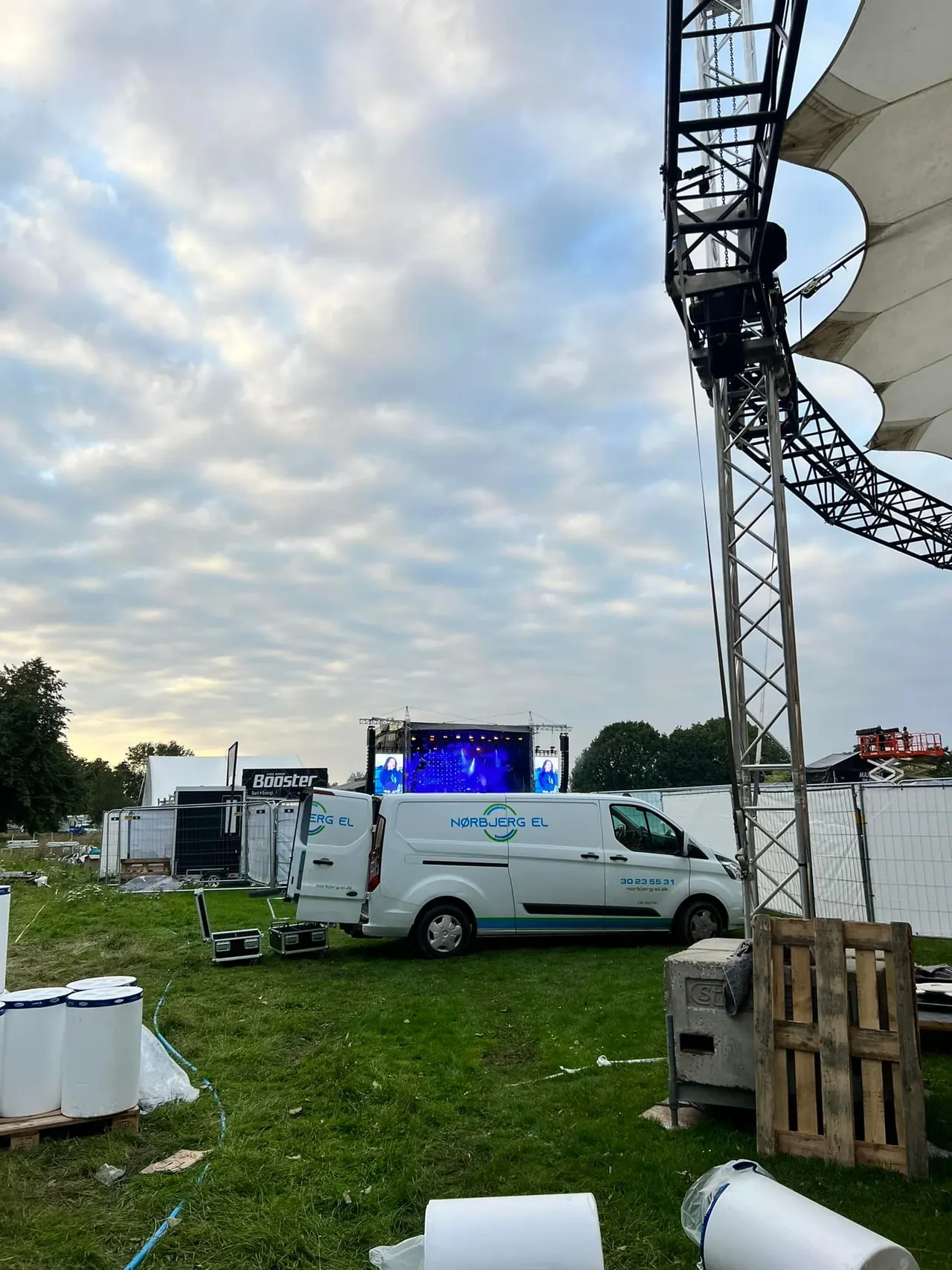 Eventplads med scene og varevogn i aftenlys