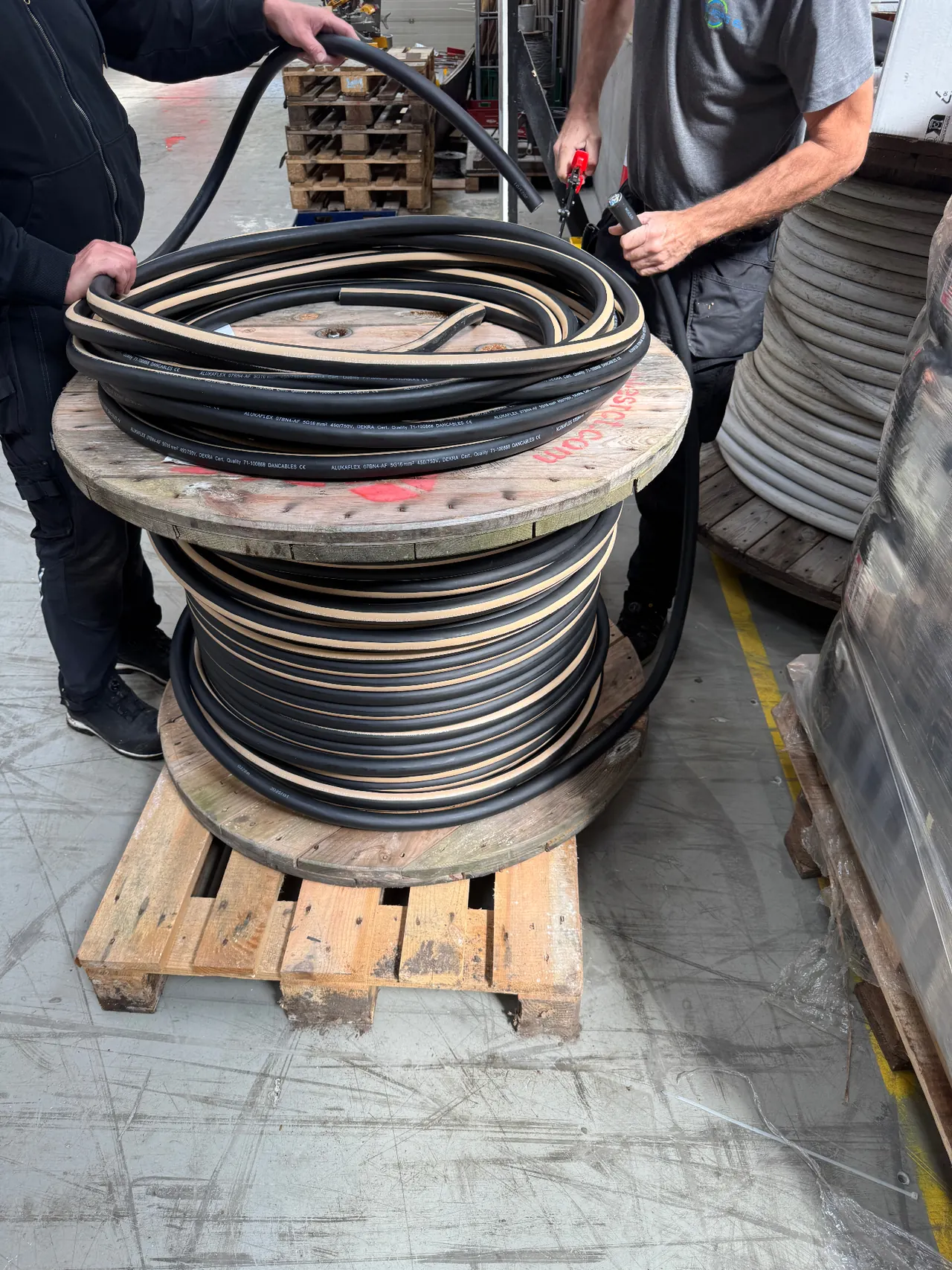 Kabeltromle med sort kraftkabel på en palle